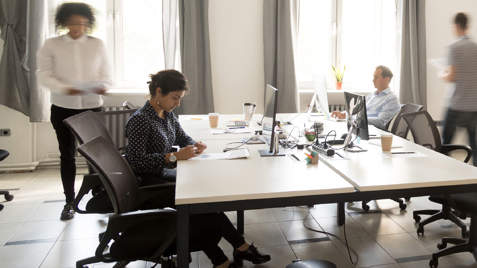 woman sitting in office looking down at paper